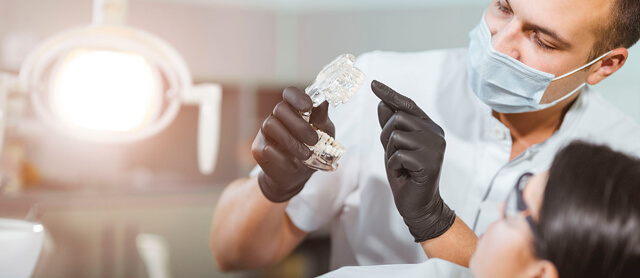 Consultório de dentista. Consulta de dentista, com o dentista a falar com a paciente sobre a saúde oral.