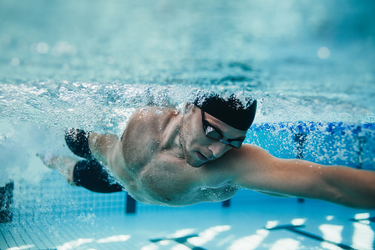 Homem a nadar numa piscina, como exercício para manter saudável o seu coração e rins.