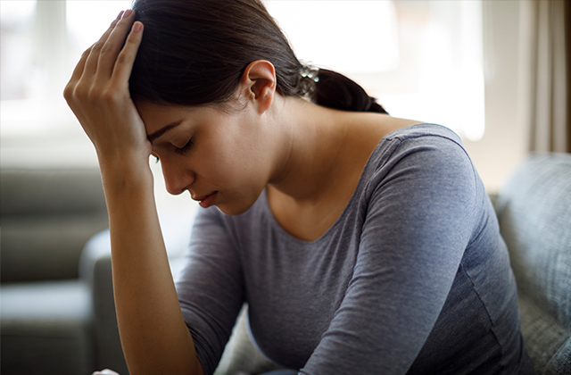 Jovem com a mão na cabeça, com um ar triste e cansado. Sinal da fragilidade da saúde mental dos jovens.