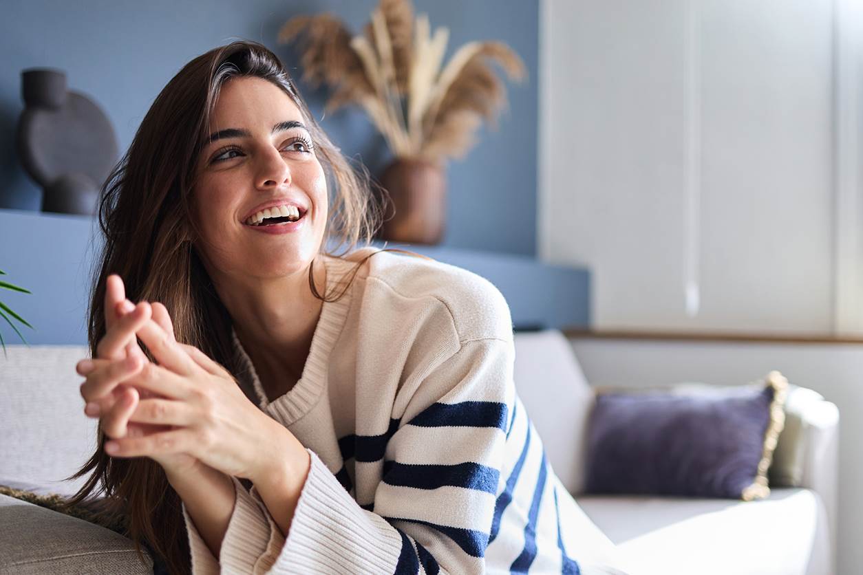 Jovem mulher, sorri por saber calcular o período fértil e reconhecer os sintomas da ovulação