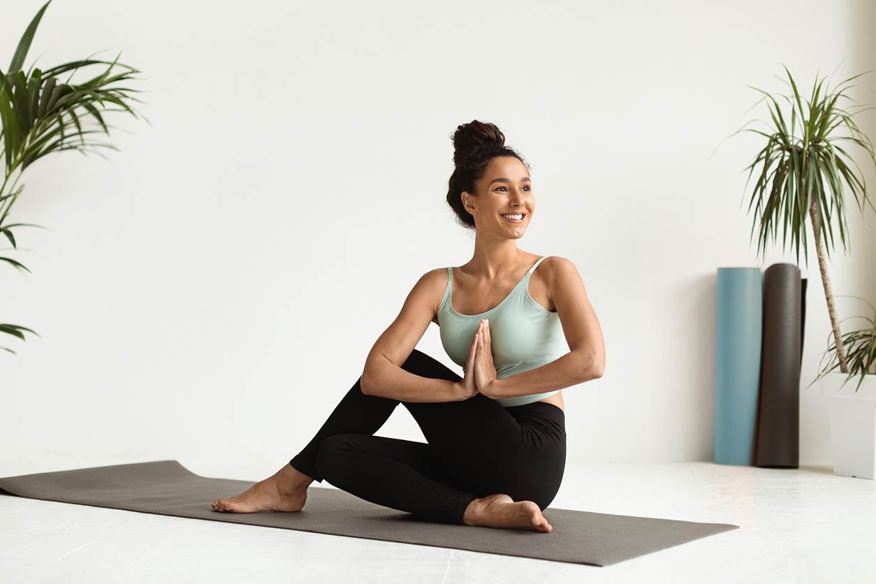 Jovem mulher pratica pilates em casa com boa disposição