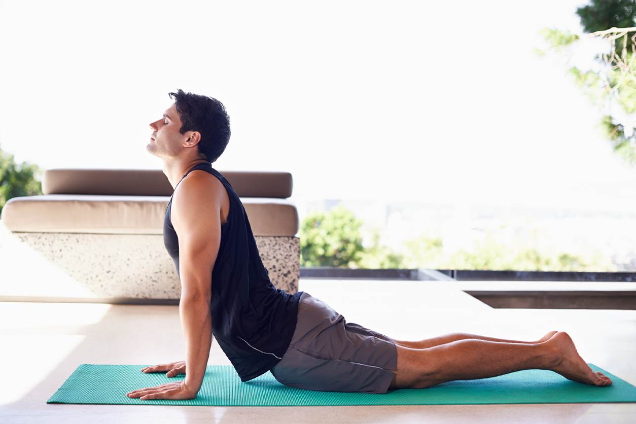 jovem rapaz pratica pilates em casa, para usufruir dos benefícios desta atividade física