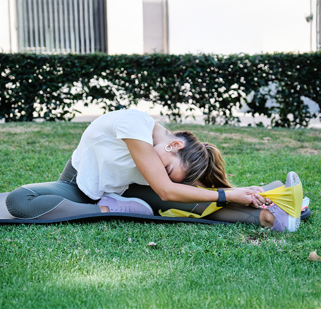 Senhora a fazer alongamentos na relva