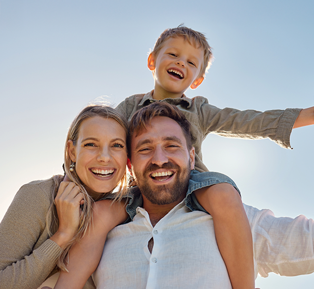 Mãe, pai e filho a sorrir para a câmera 