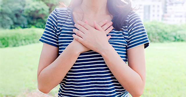Rapariga com as mãos em cima do peito