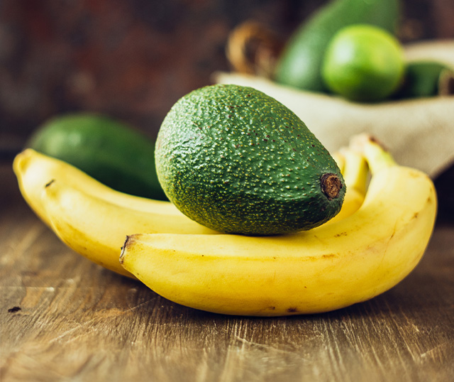 Abacate e bananas em cima de uma mesa