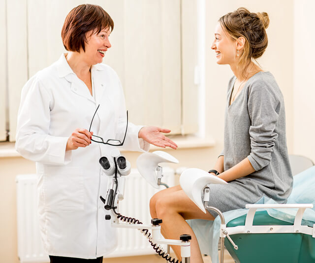 Médica e paciente no consultório do exame de Papanicolau